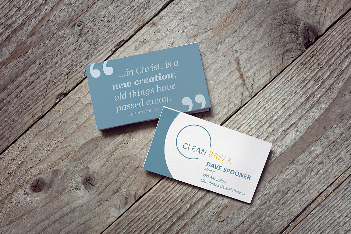 Front and back of Clean Break business card on wood table.