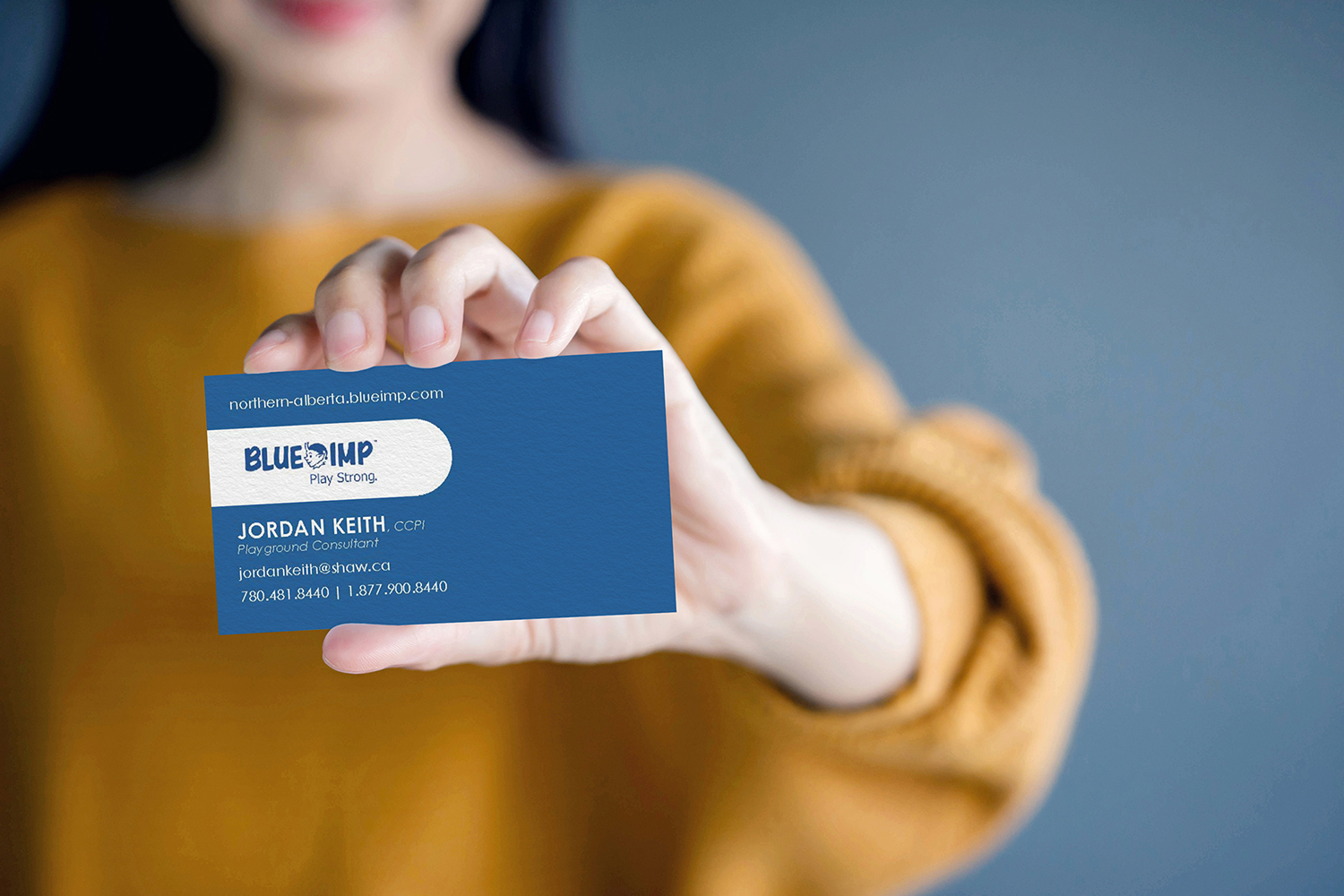 Woman holding Blue Imp business card.